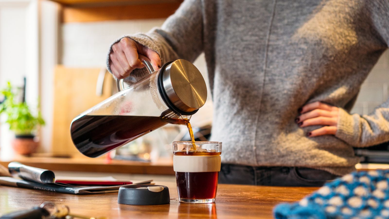 en mann som heller kaffe fra en kaffetrakter i et glass
