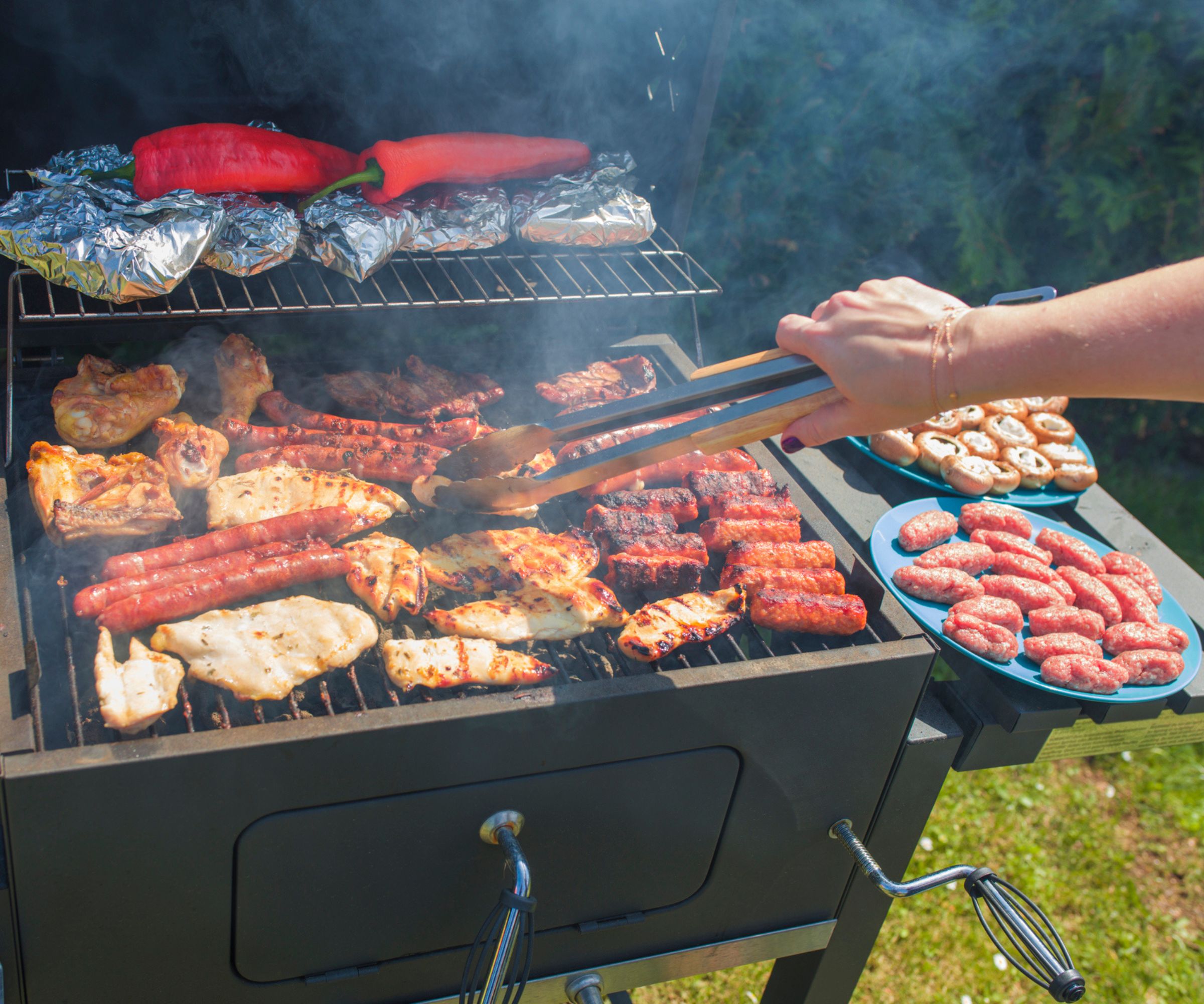 Grilling av pølser, kyllingbryst og paprika på åpen grill