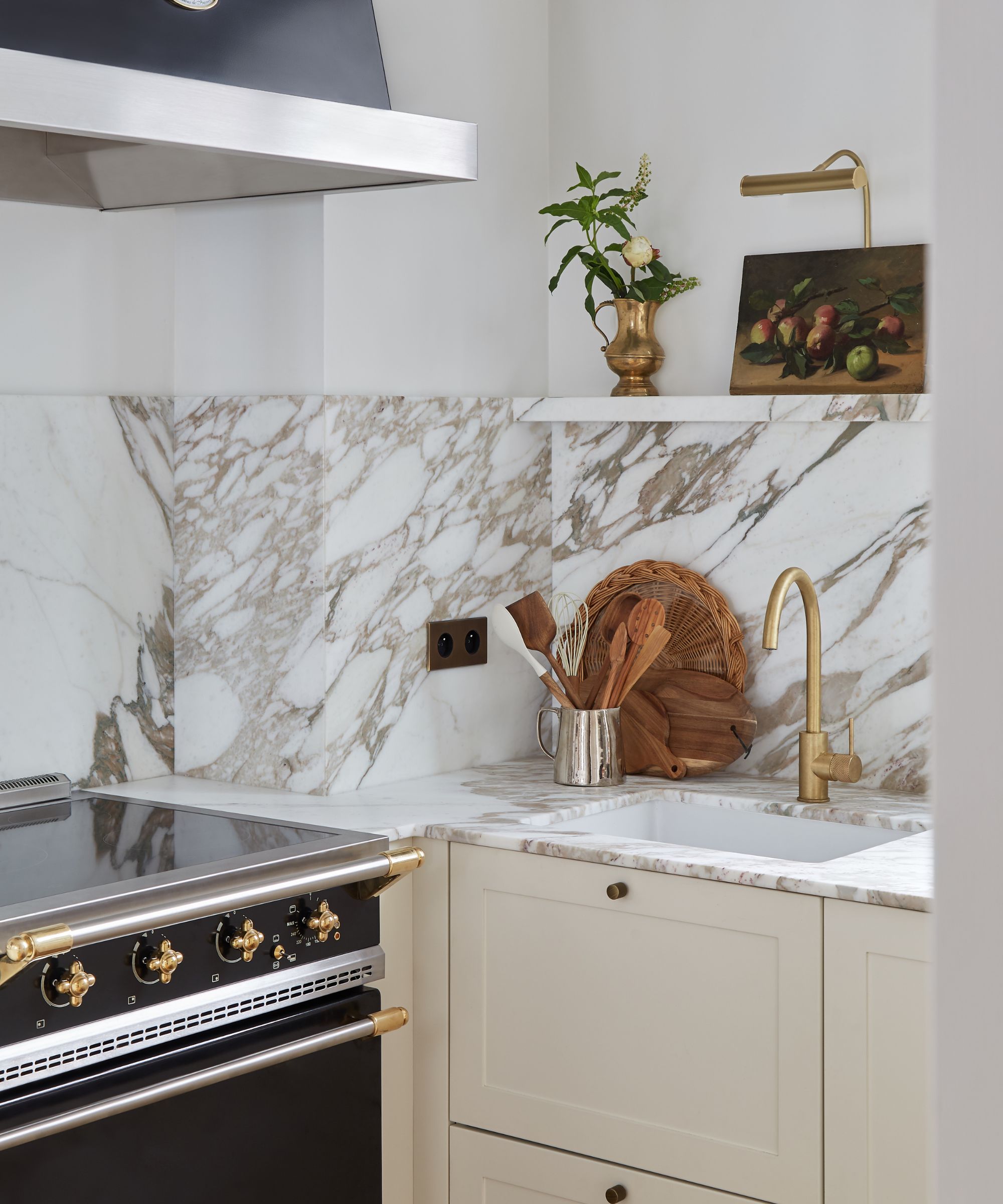 kjøkken med krem enheter og marmor backsplash
