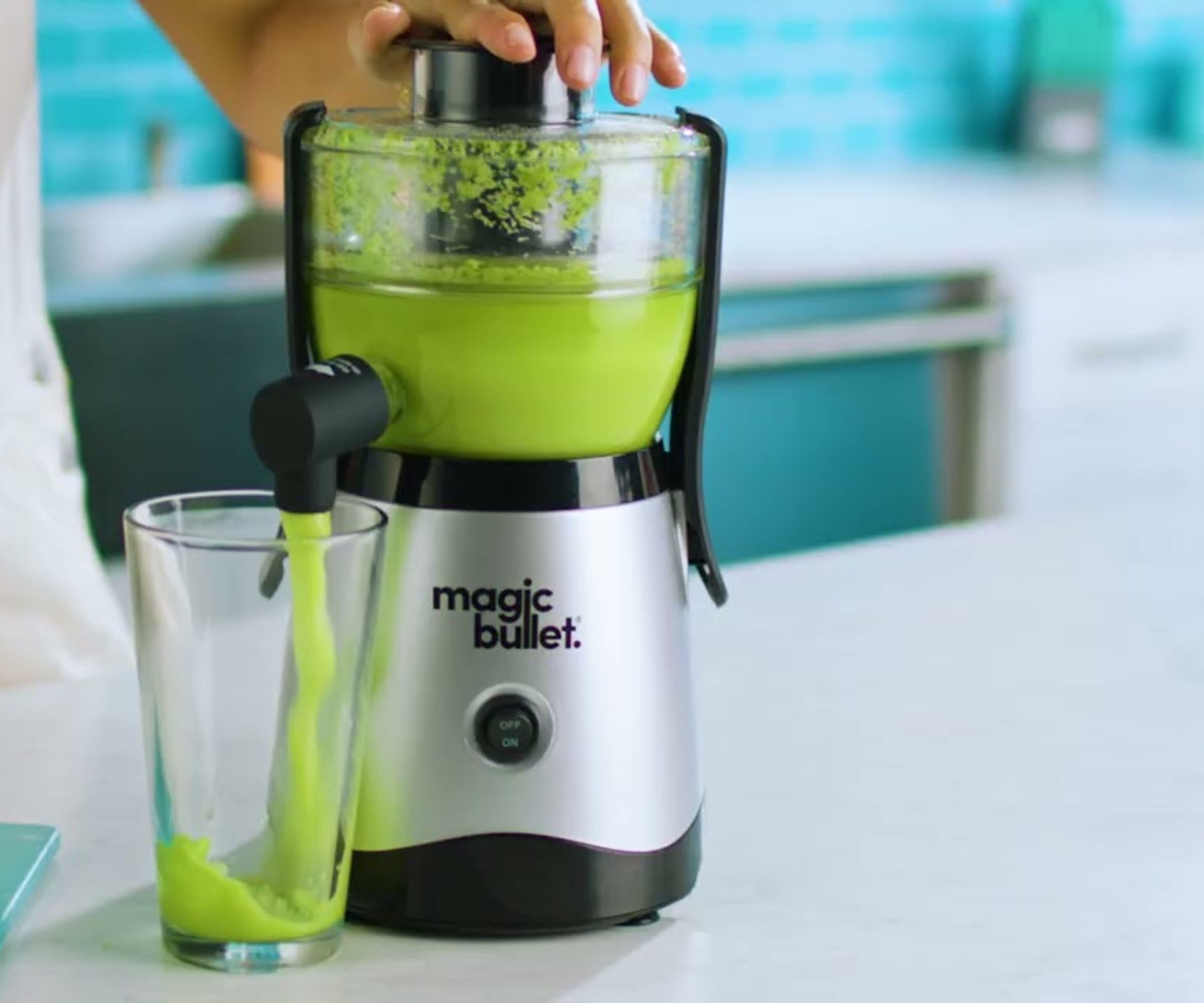 Magic Bullet Mini Juicer som lager grønn juice på en hvit benkeplate