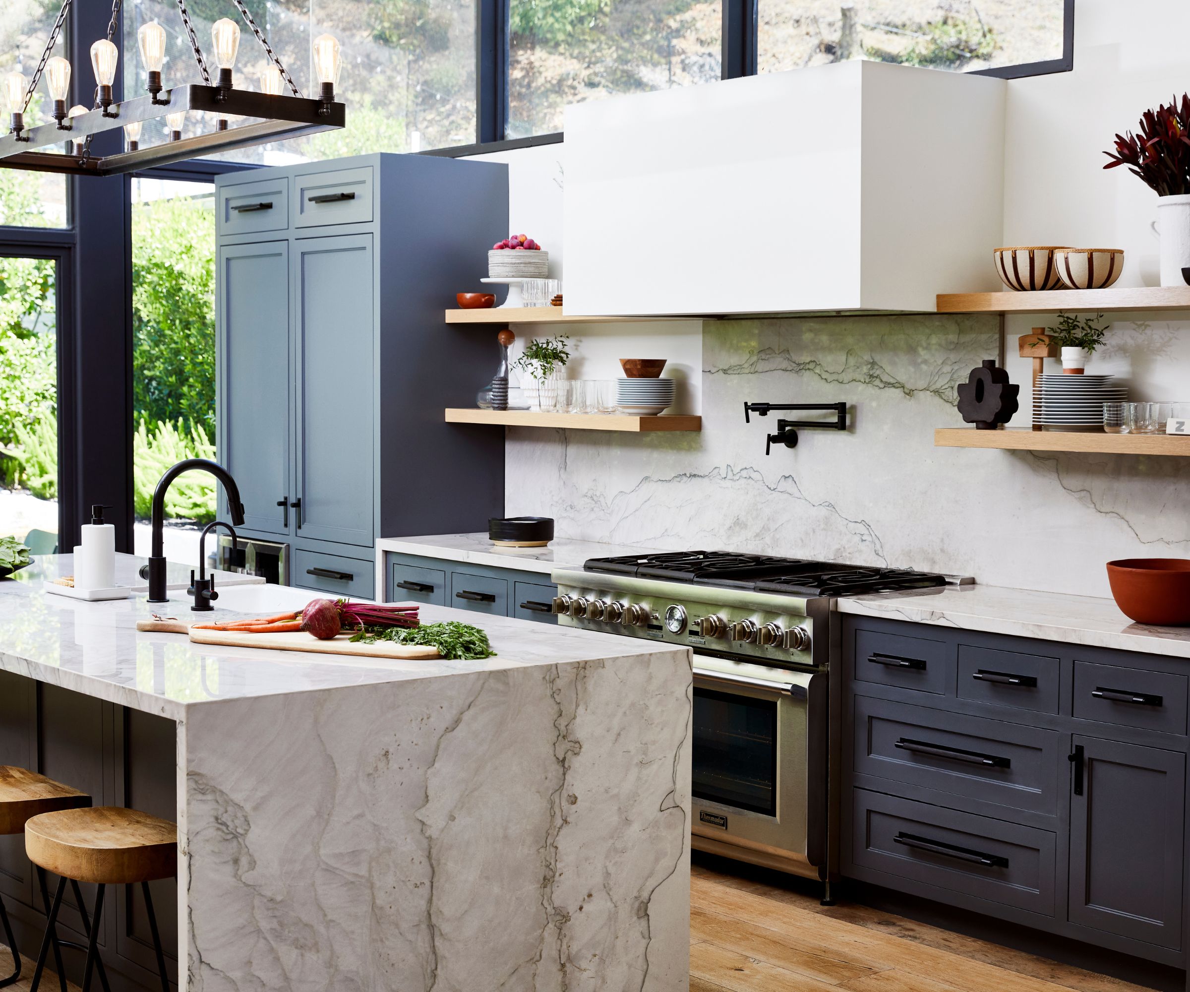 kjøkken med blå enheter full høyde glass marmor toppet øy og backsplash