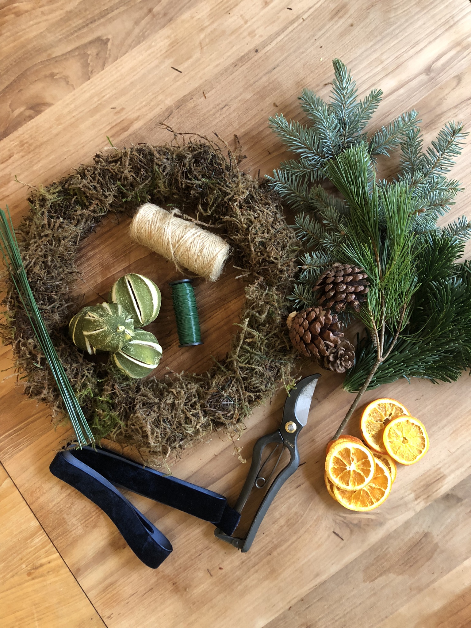 Flatt legging av moset krans, løvverk og tørkede ingredienser for å lage en julekrans