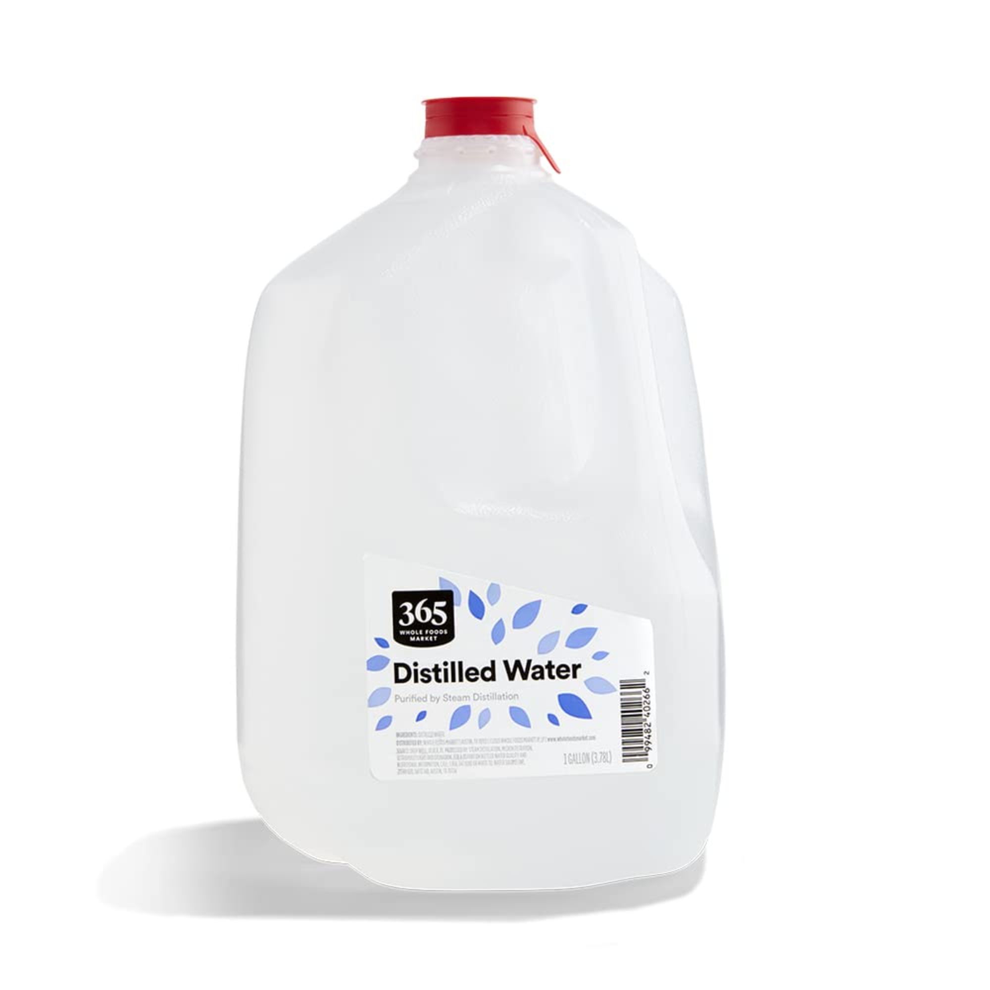 En plastflaske med destillert vann med rød kork og blå og hvit etikett