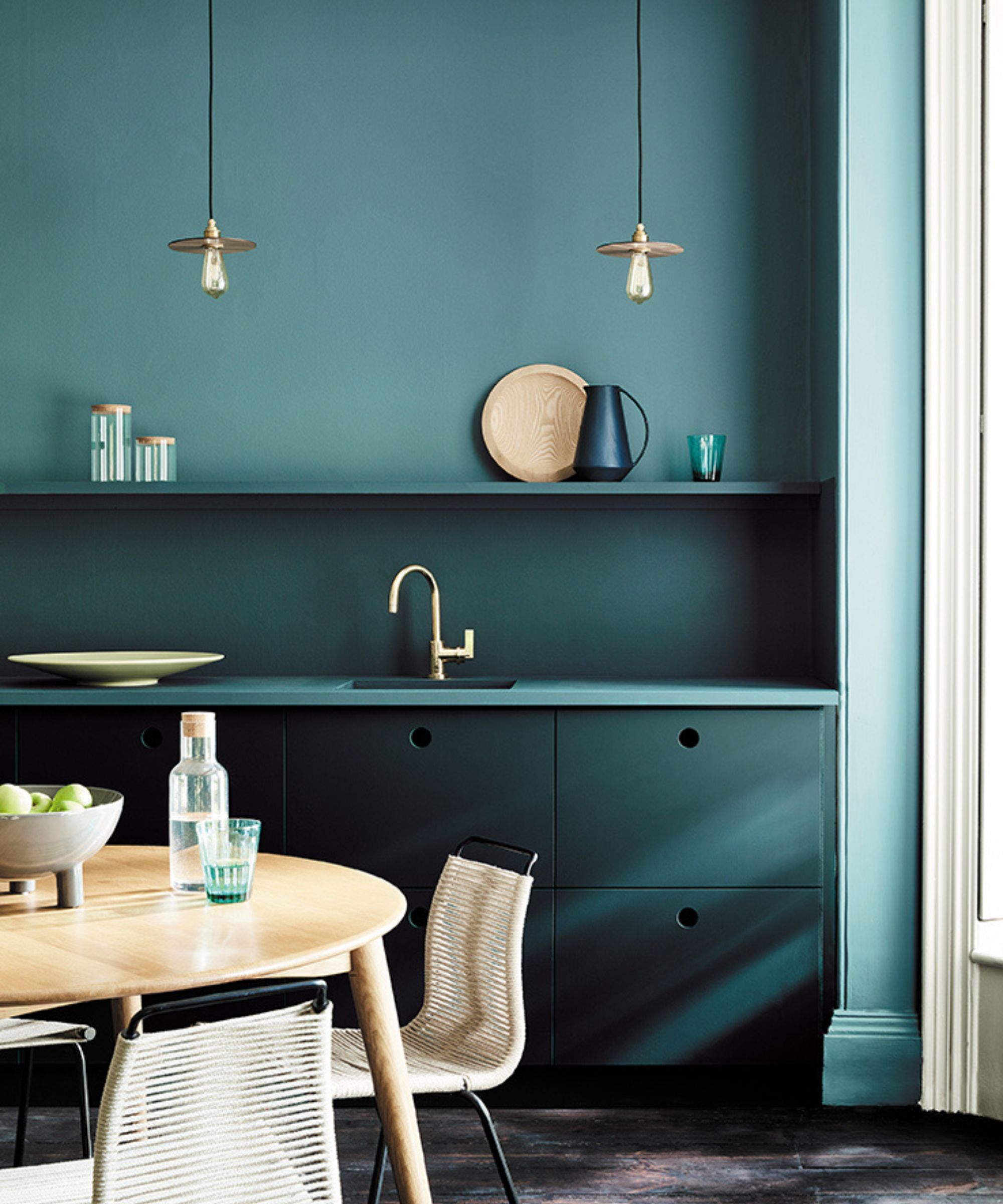 Et fargegjennomvåt kjøkken med turkise vegger og turkis skap i en elegant, moderne design