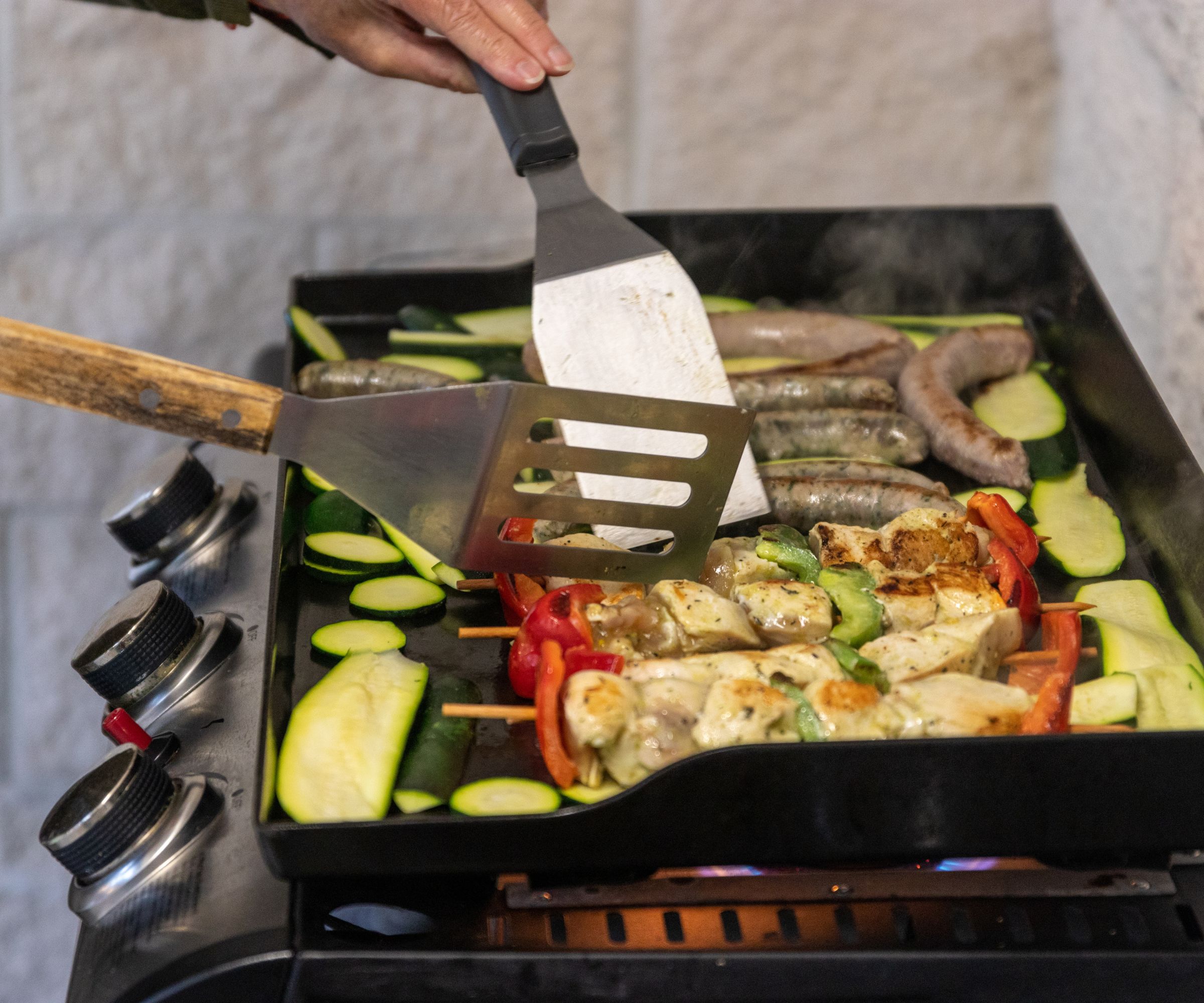 Koking av pølser, kebab og zucchini på en takke