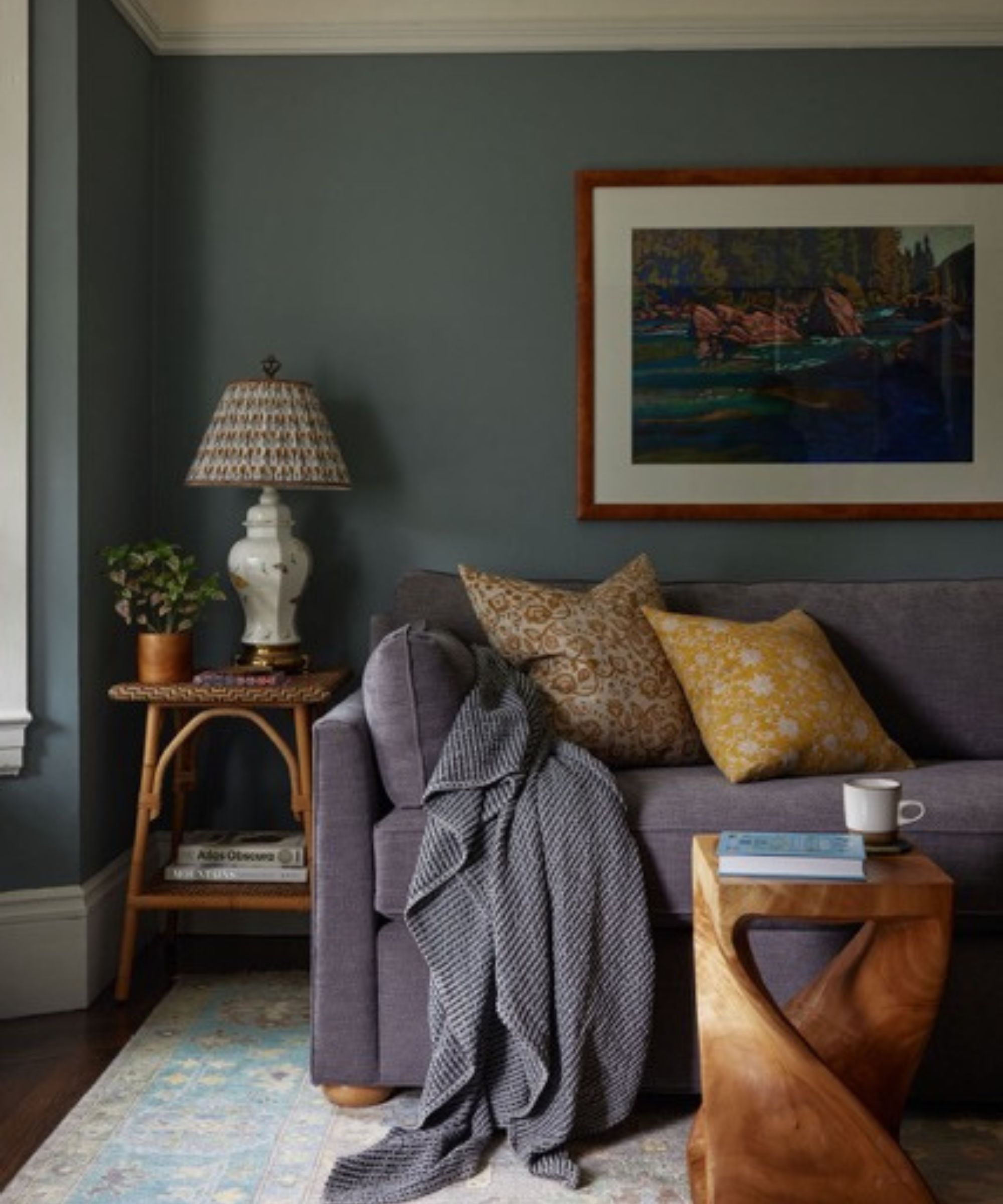 Mørkegrått hjemmekontor med mørkegrå sovesofa og sidebord i tre