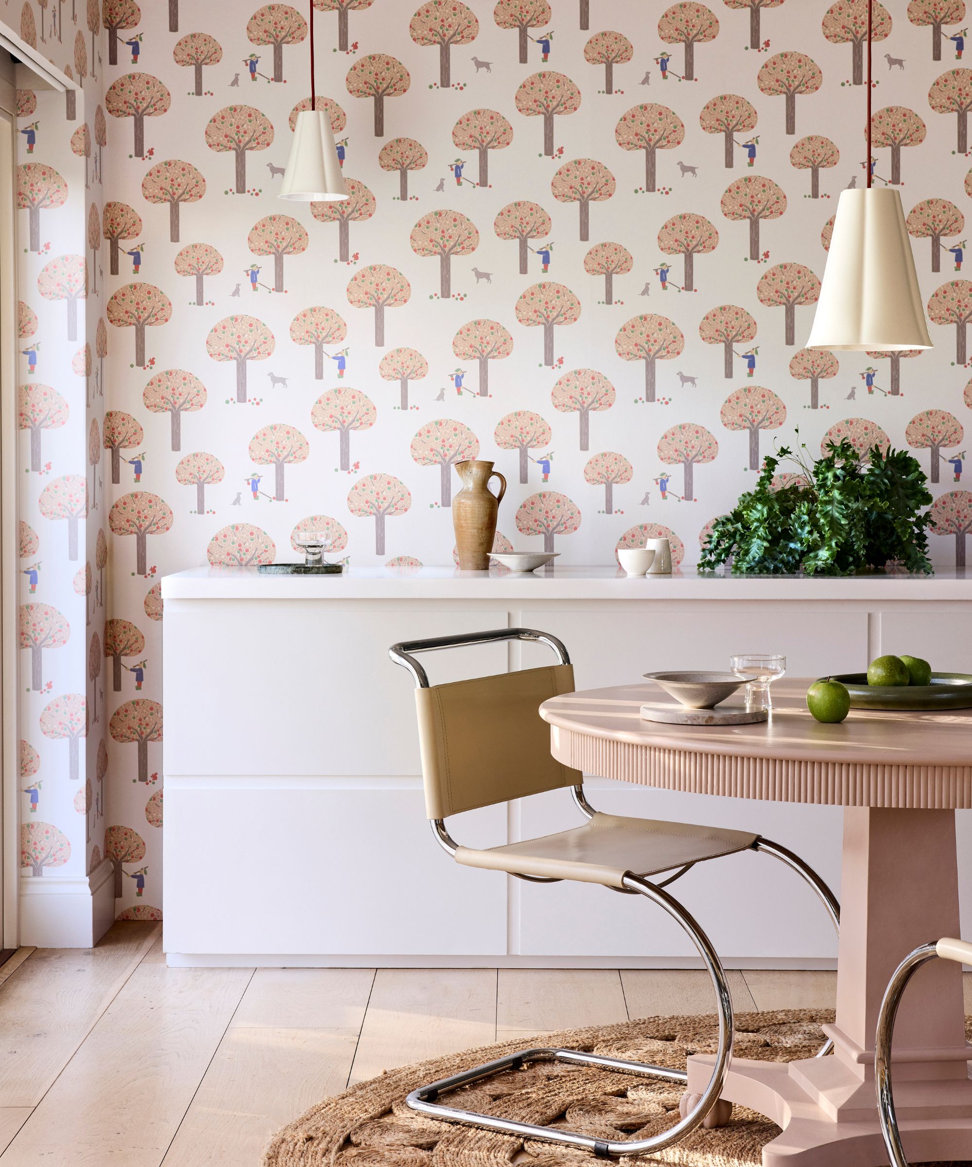 Spising er med blek rosa skogsmønster bakgrunn, hvit skjenk, rundt spisebord med moderne skulpturell stol