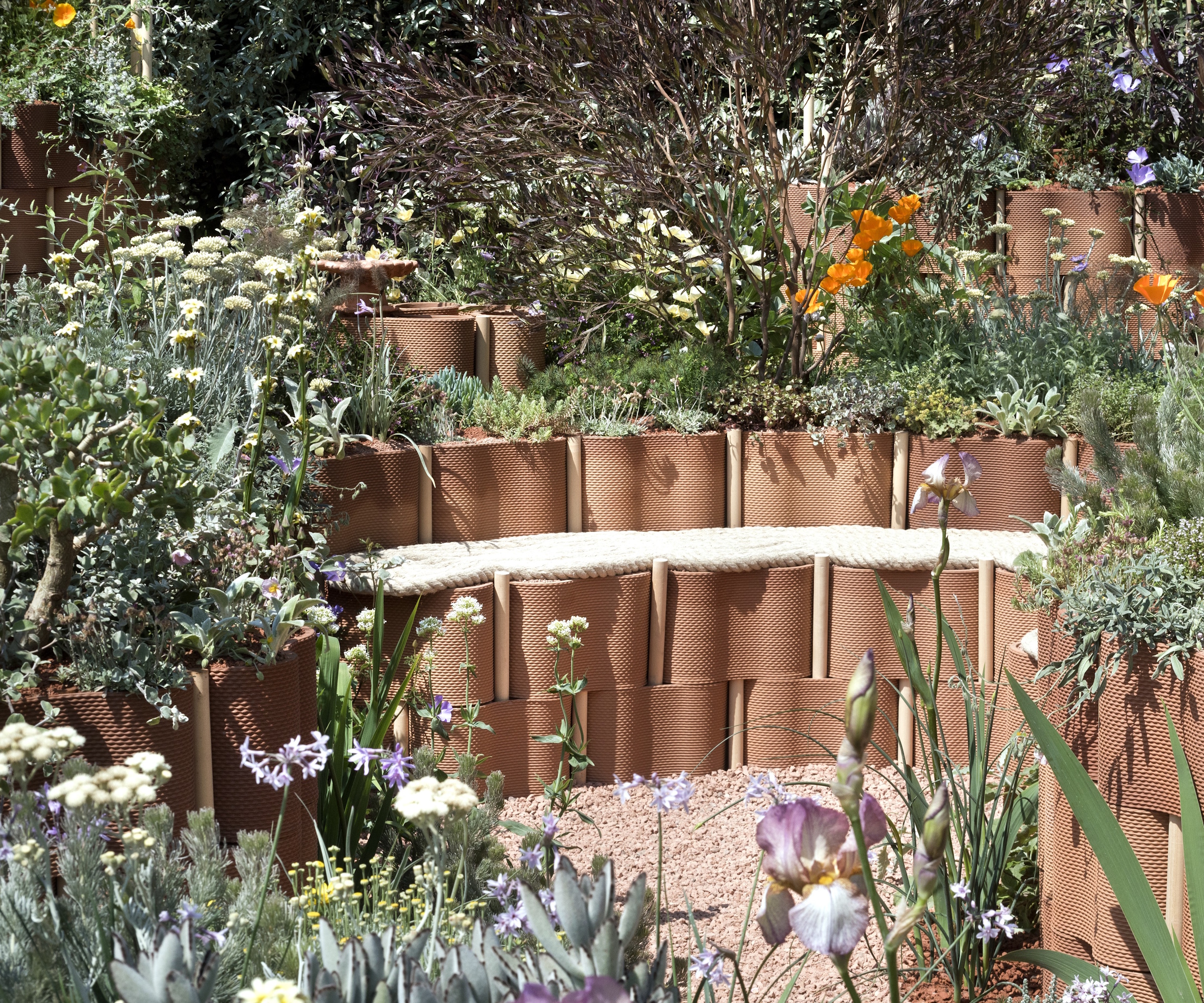 RHS Chelsea Show Garden med terrakotta sitteplasser og villblomster