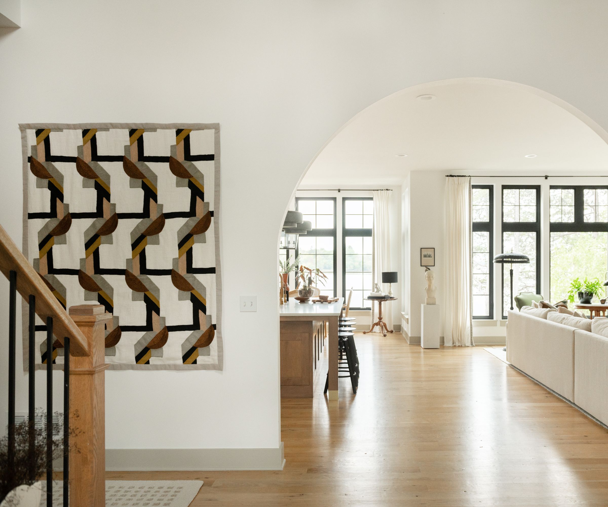 Moderne nøytral inngangsparti med en buet åpning ved siden av en moderne Pierre Frey Tapestry Wall Hanging