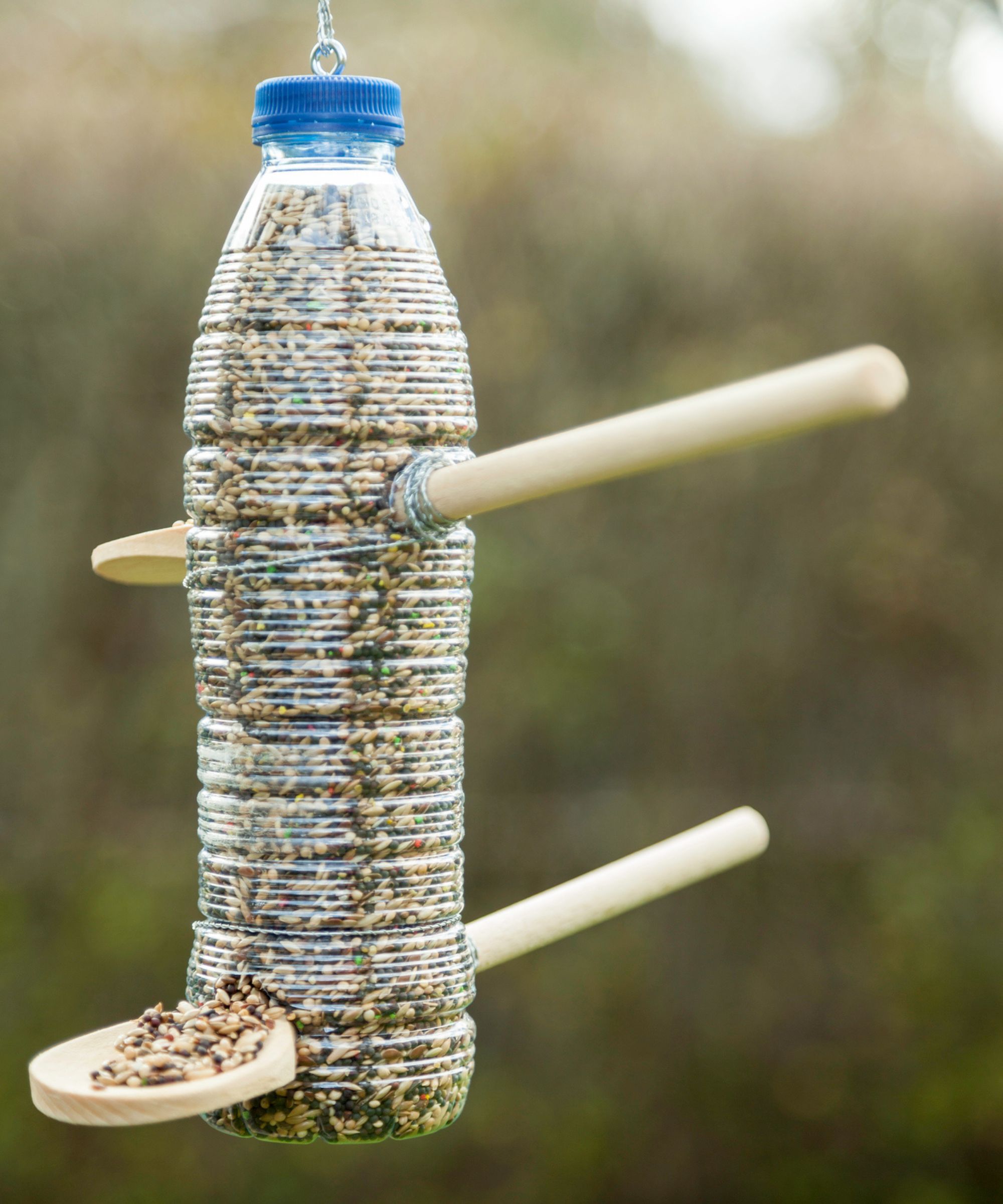 En DIY -flaskefuglmater med skjeer som dowels