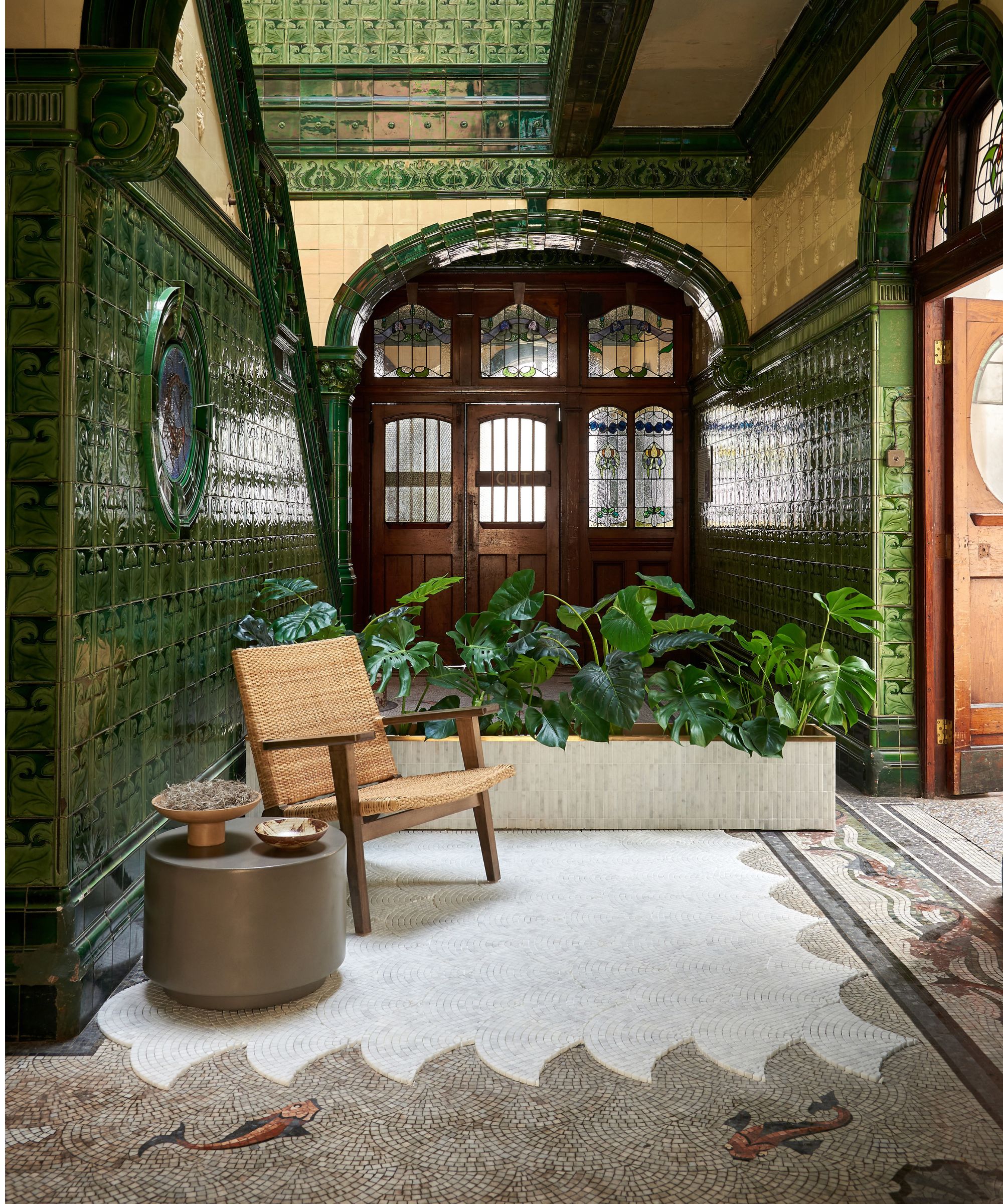 Grønn flislagt gang i Art Deco -stil med mosaikkgulv med fisk og bølgedesign