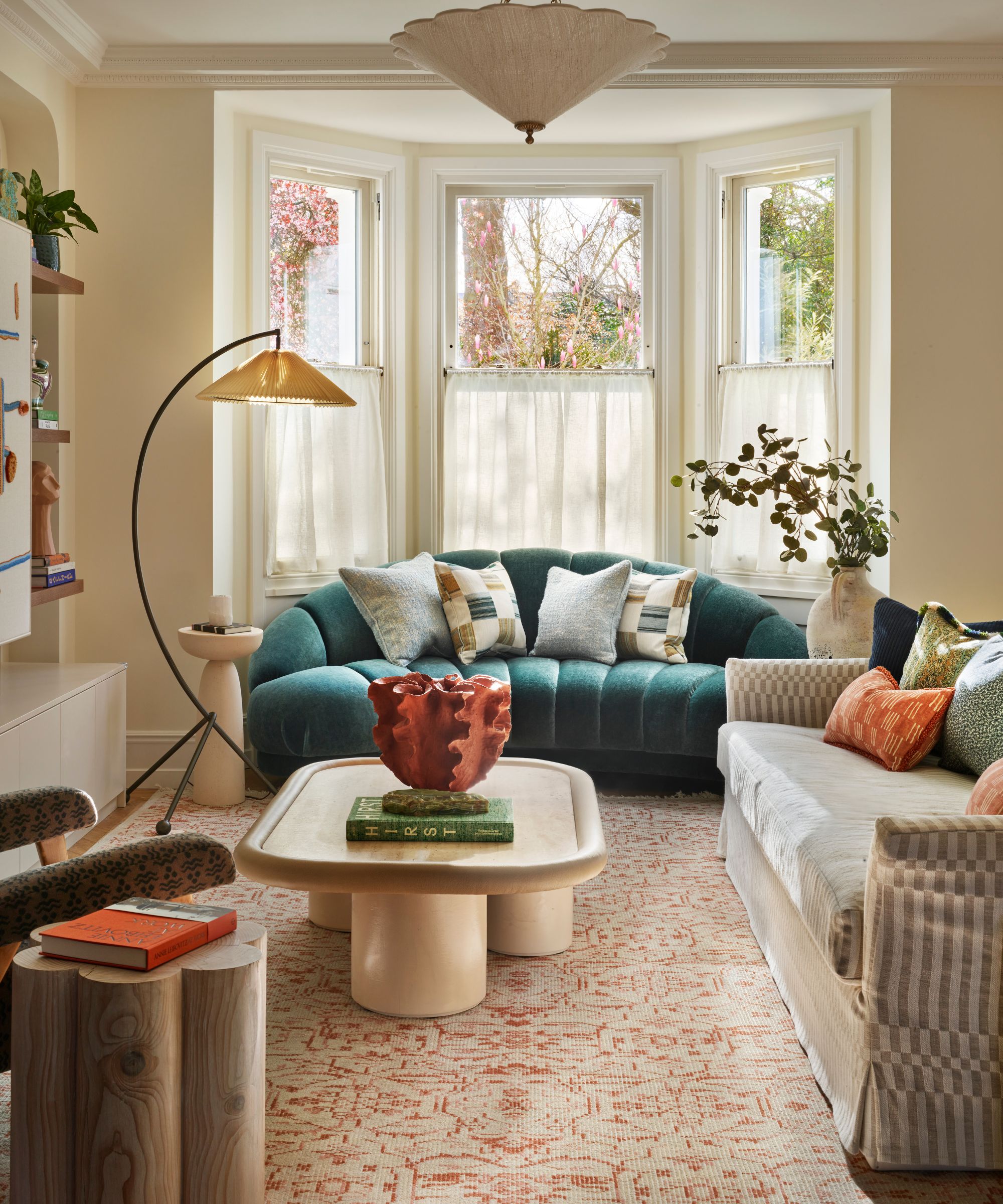 Nøytral viktoriansk stil stue dekorert med eklektisk blanding av moderne og vintage møbler inkludert en buet teal sofa