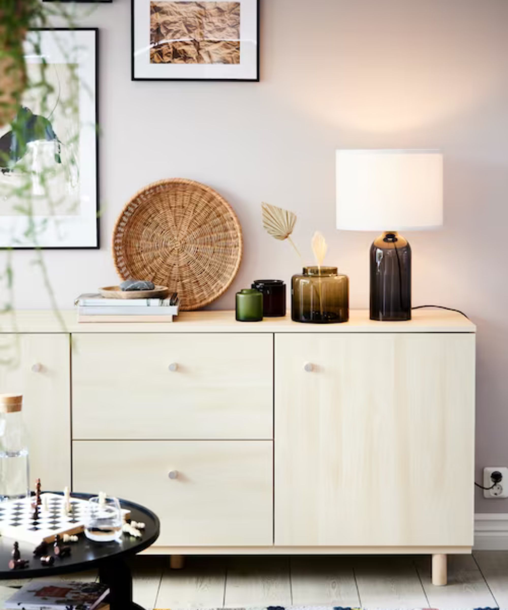 Blek tre med en lampe, vaser og en haug med bøker på overflaten