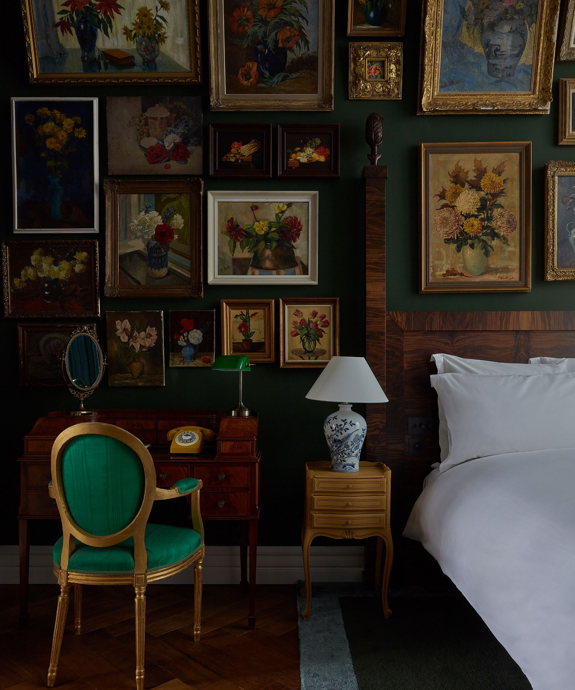 Vintage Style Dark Green Amsterdam Hotel Soverom med en stor antikvitetsvegg av blomstermalerier i hyllest til den nederlandske beliggenheten