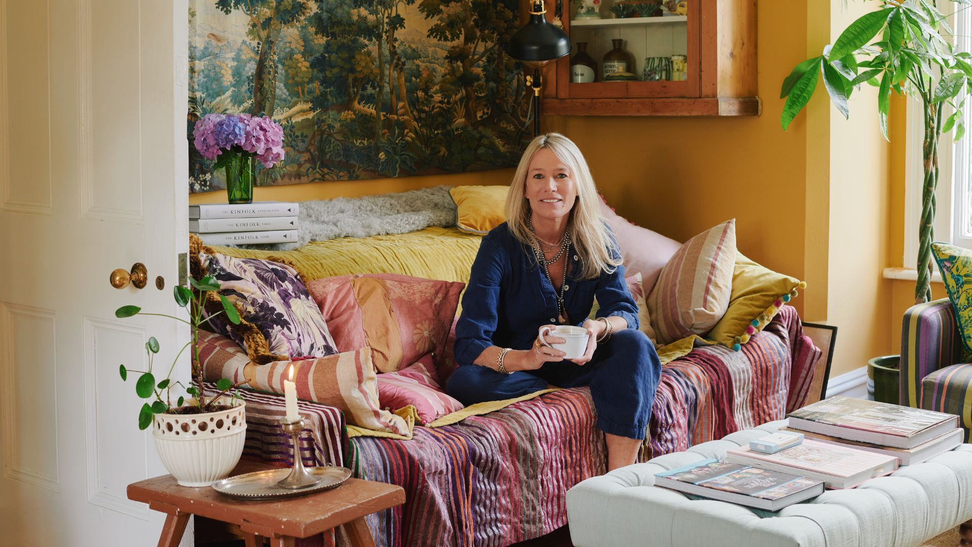 A woman on a colourful sofa holding a mug