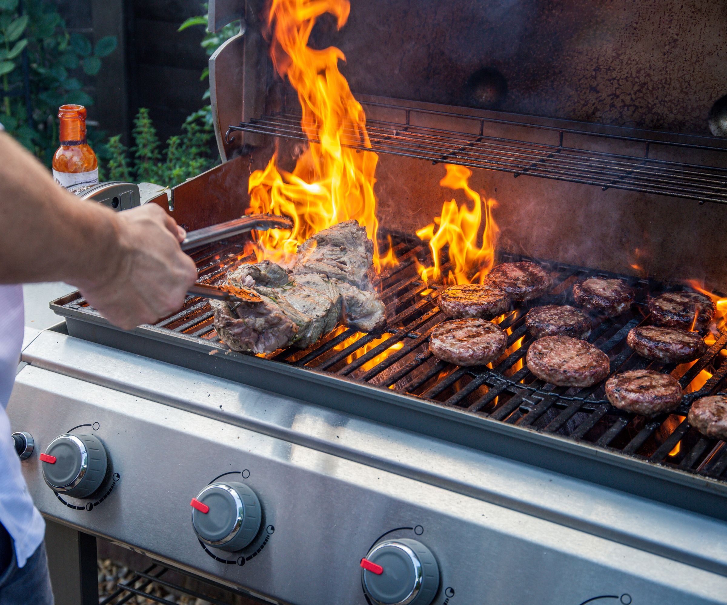 Grilling lam og burgere på en stor gassgrill