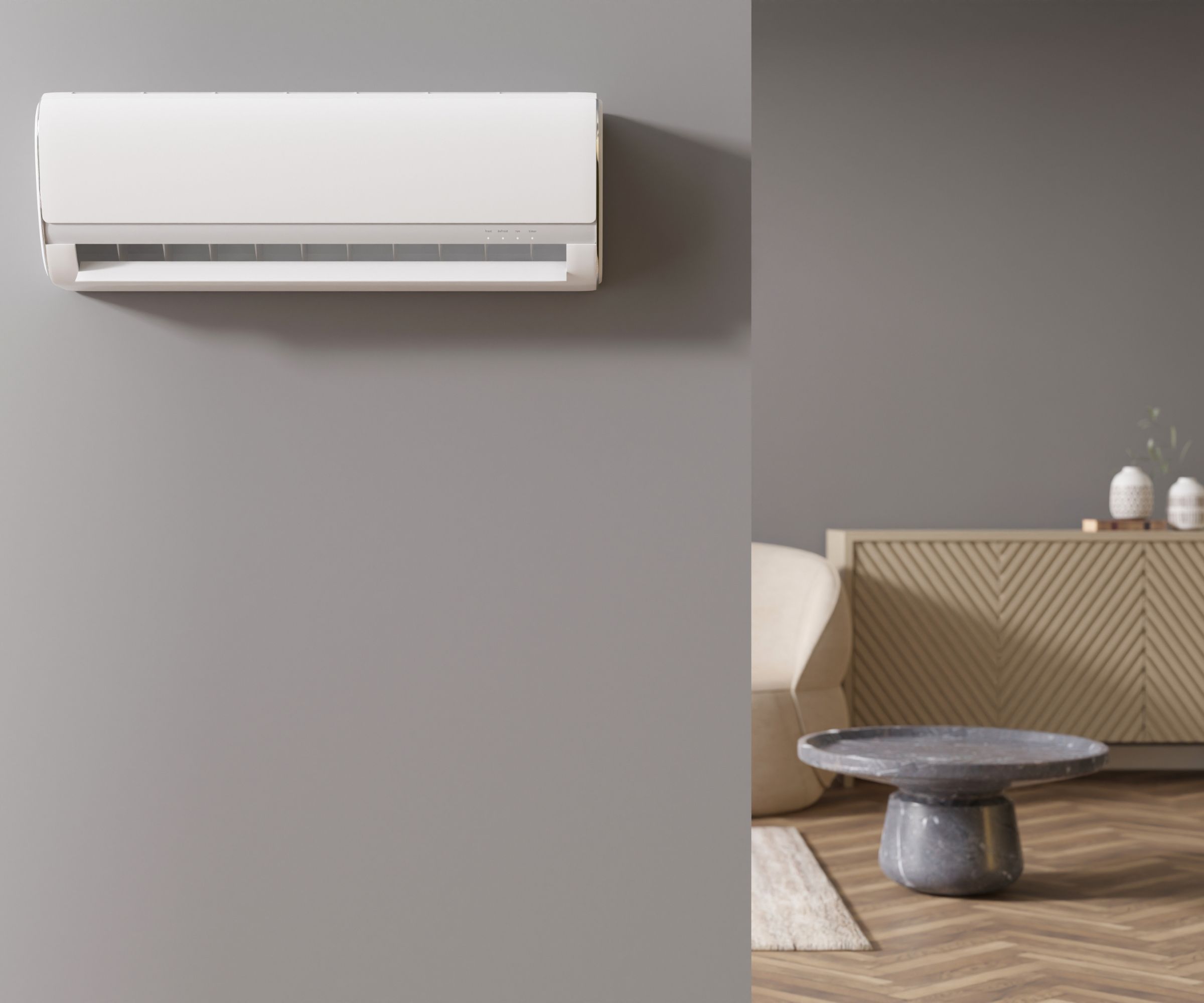 En hvit HVAC Fen -enhet montert på en gråmalt vegg. En stue som er synlig gjennom en døråpning til høyre side.