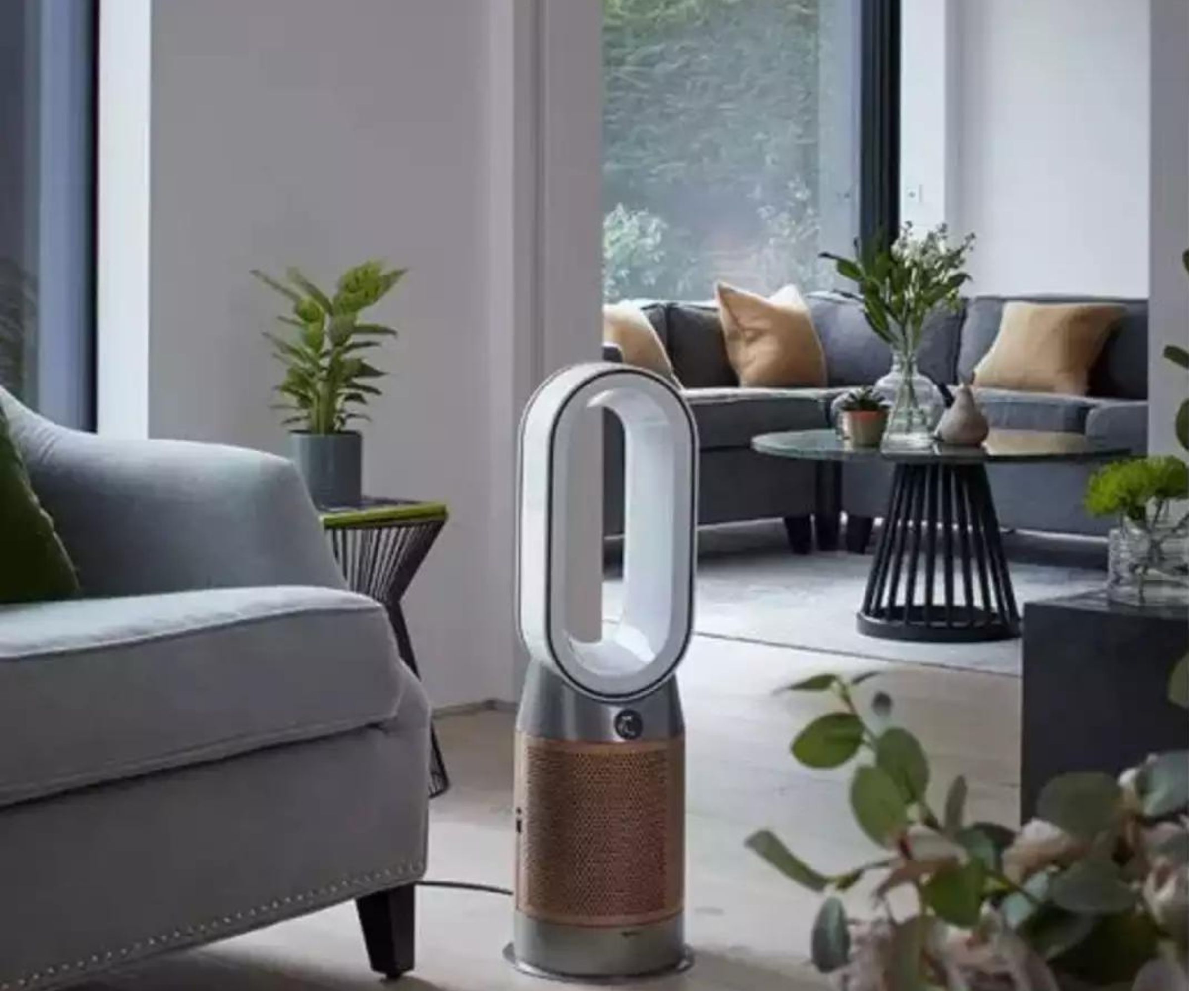 Dyson luftrenser ved siden av en sofa i en stue.