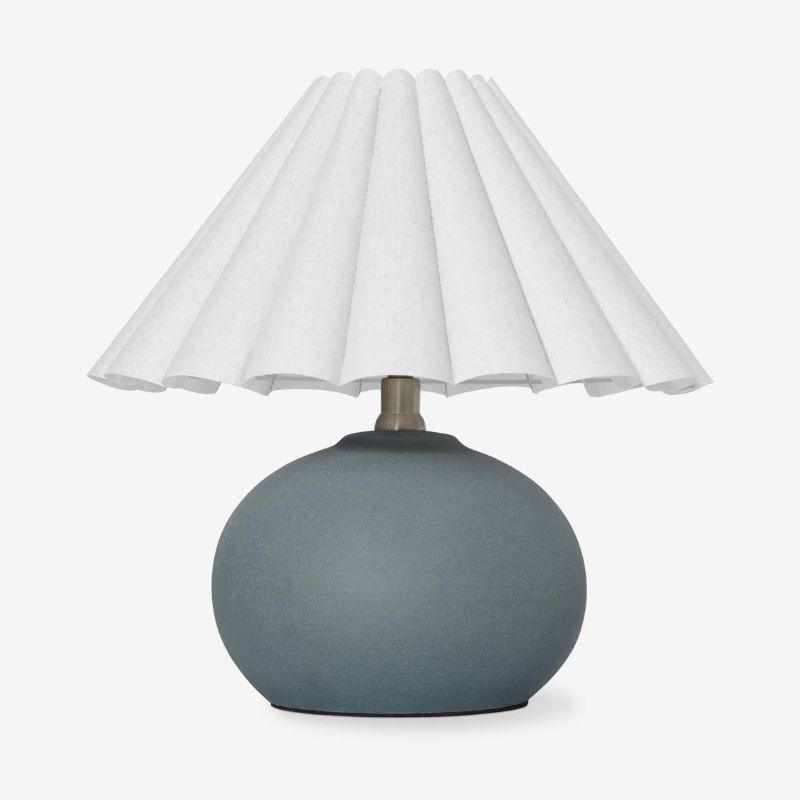 bordlampe med dempet blå avrundet base og hvit plissert nyanse