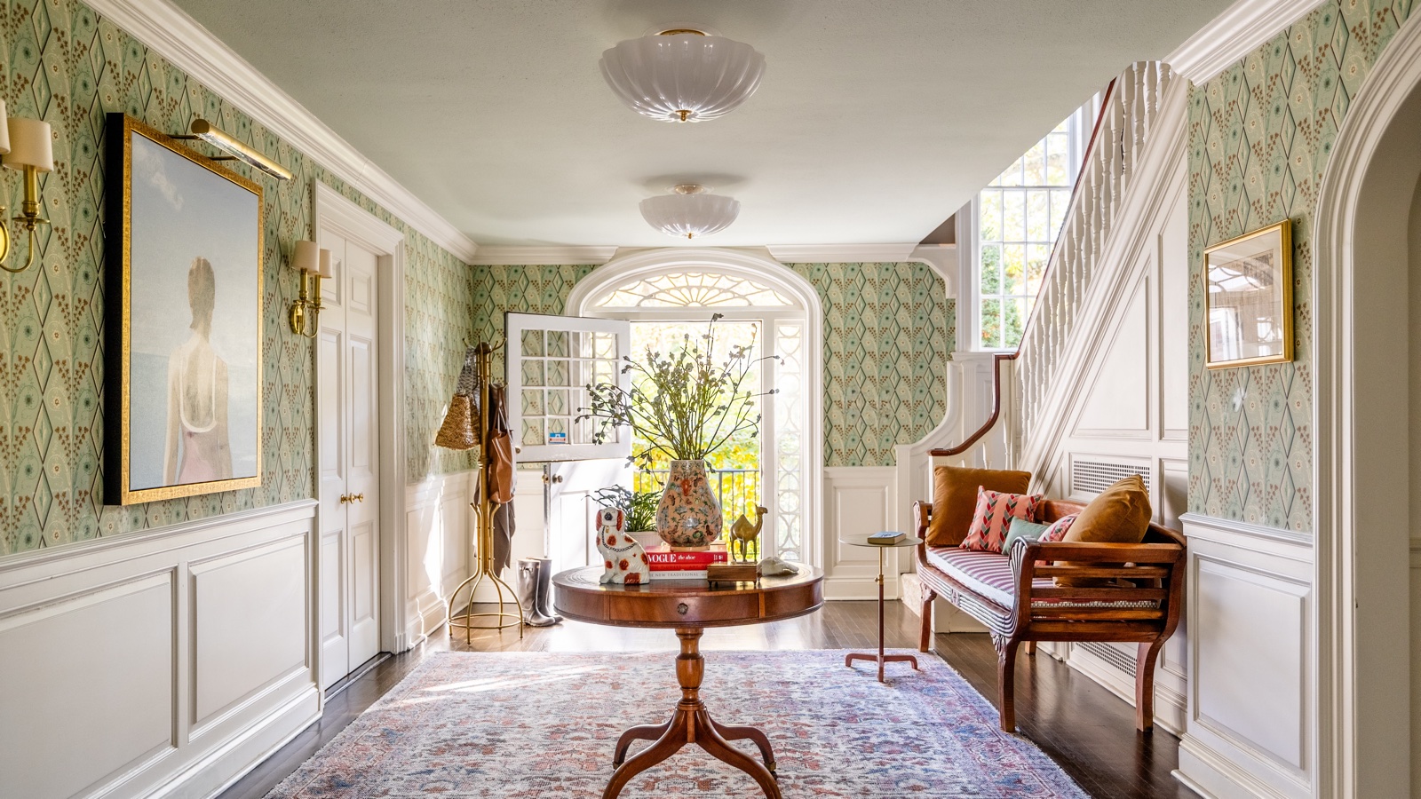 opulent entryway with round table, wallpaper and oversized art by Camden Grace Interiors