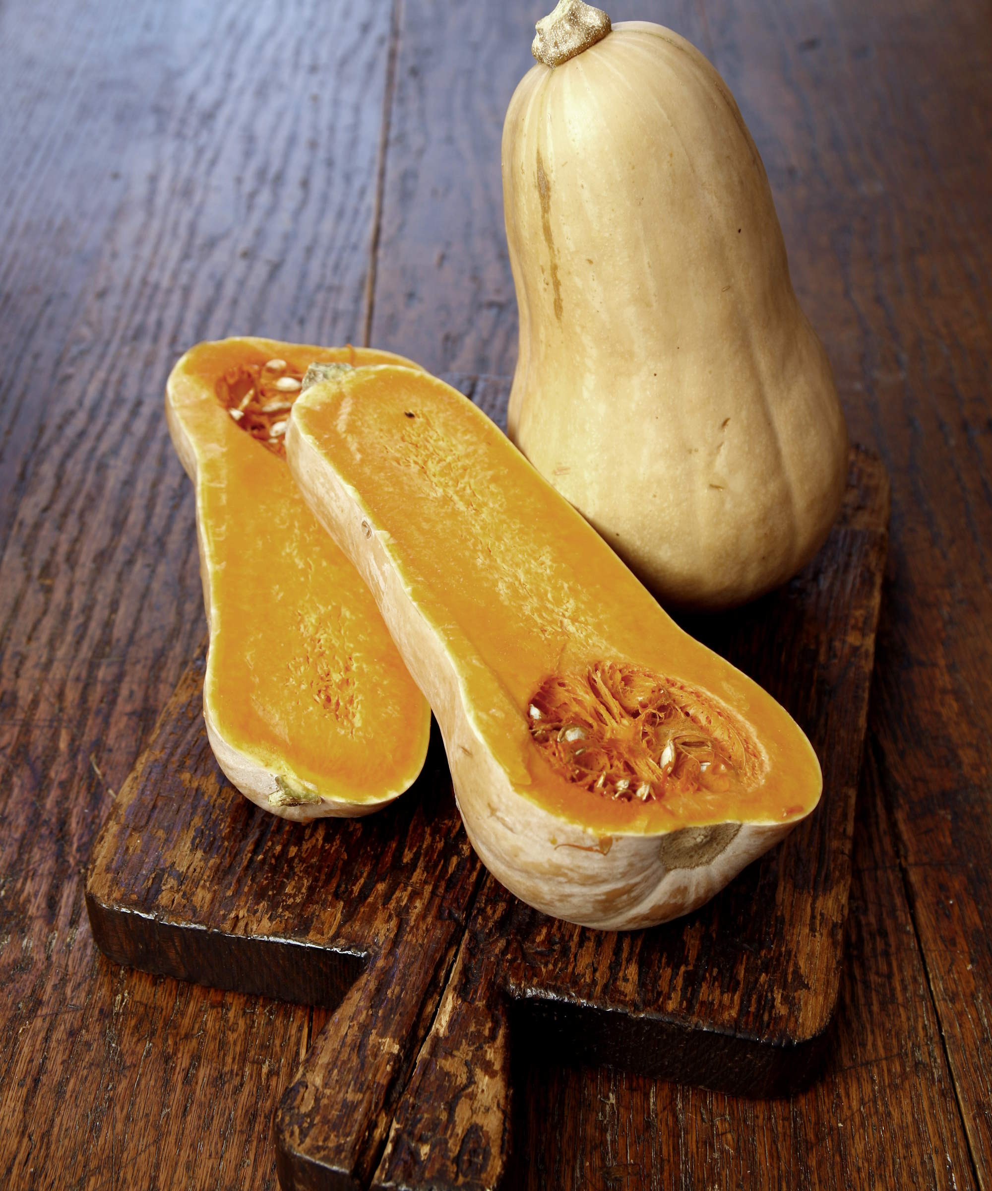 En butternut squash hel og skiver på et treplate